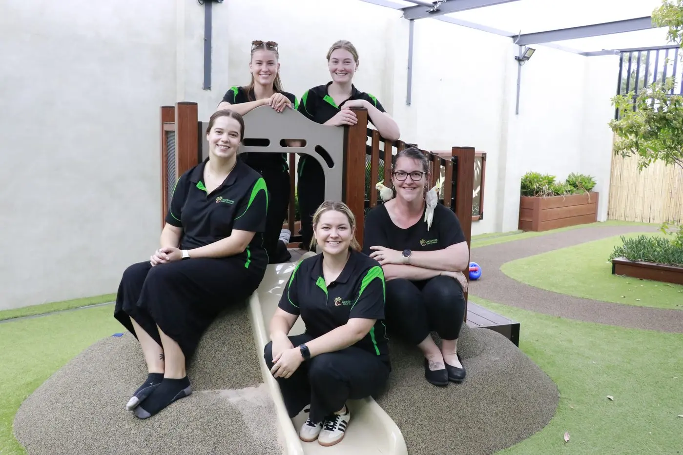 Educators (back) Ella Greenhalgh, Kate Stewart (front) Ebony O\\'Malley, Maggie Hanley and centre director Michelle Catherwood with cockatiels Sugar and Spice.