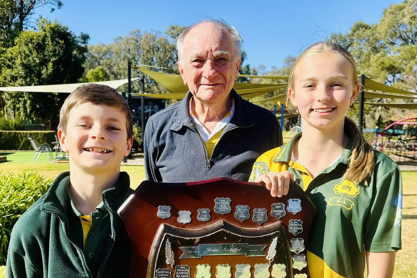 Richard Neate from Cowra Eisteddfod visited Bedgerabong Public School to present the shield to captains Hunter Maxwell and Georgia Pengilly. PHOTO: Supplied