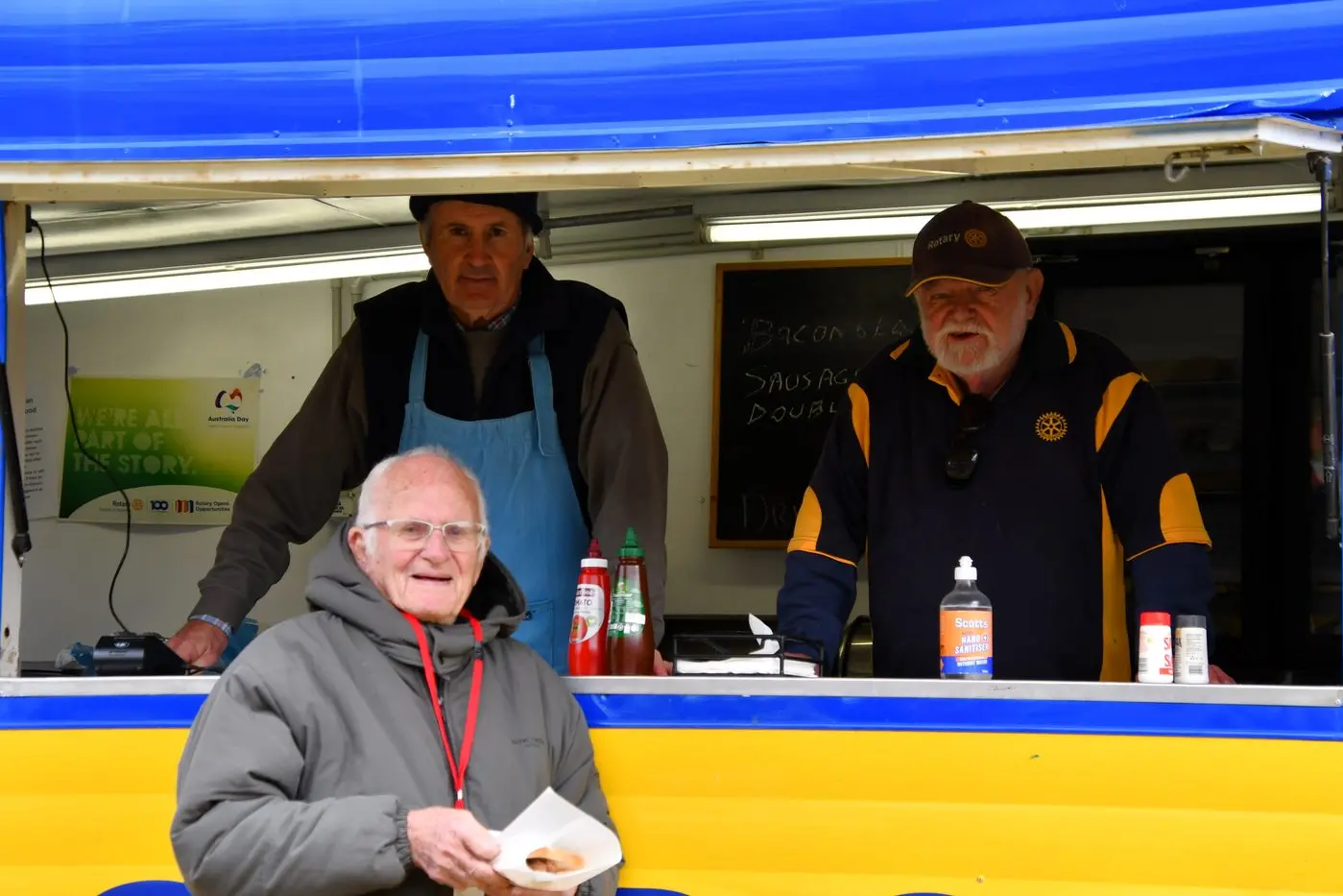 Ross Williams and Chris Finkel serve Lloyd Gerdes his sausage sandwich. PHOTOS: Jenny Kingham