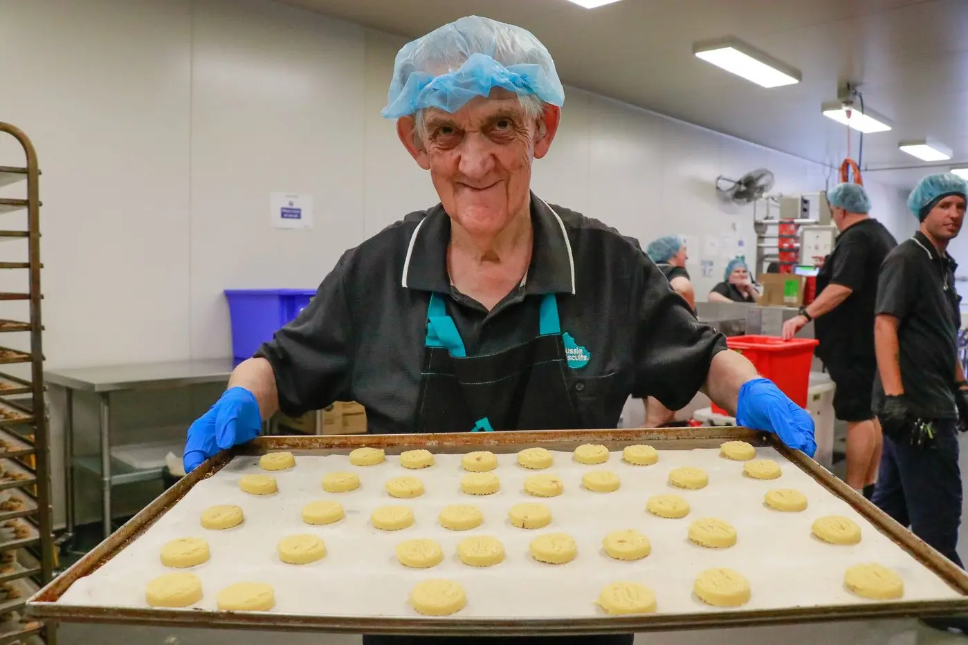 Kevin Green delivering a tray of bikkies to the oven.
