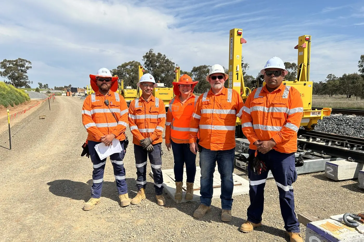 Inland Rail Skills Academy graduates (from left) Hamilton Currie, Brett Whyman and (far right) Lawrence Button with Inland Rail\\u2019s Cathy Duncan, Senior Program Skills and Training Advisor, and Adam O\\u2019Sullivan, Rail Superintendent, Martinus (second right). The graduates gained employment with Martinus Rail and made use of their training during the September possession at Forbes. They say Inland Rail was a great help in securing their training and placement in the rail construction industry.