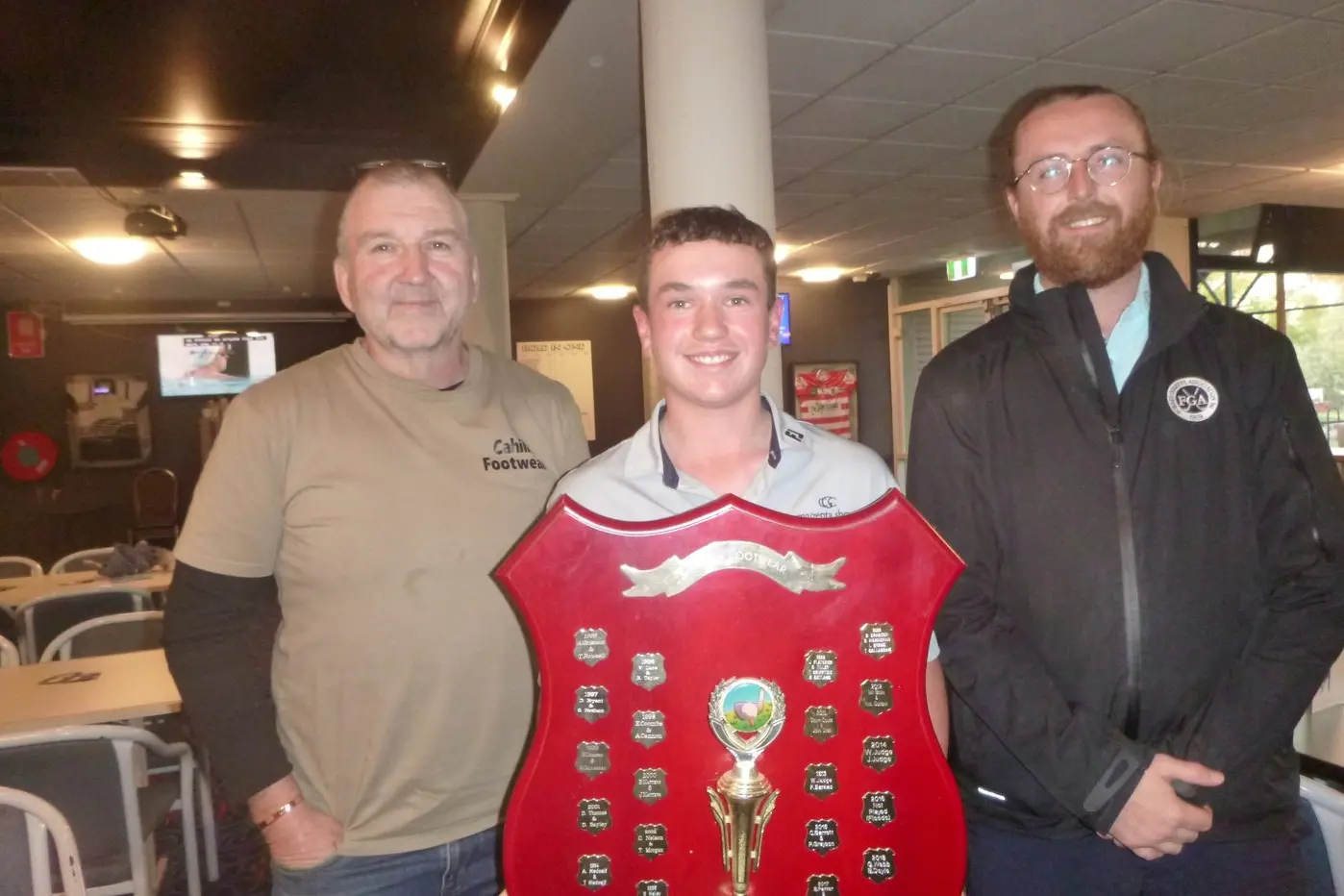 Sponsor Marty Cahill presents the Shield to Archie Quirk, representing the winning team, alongside Head Pro Will. Picture supplied