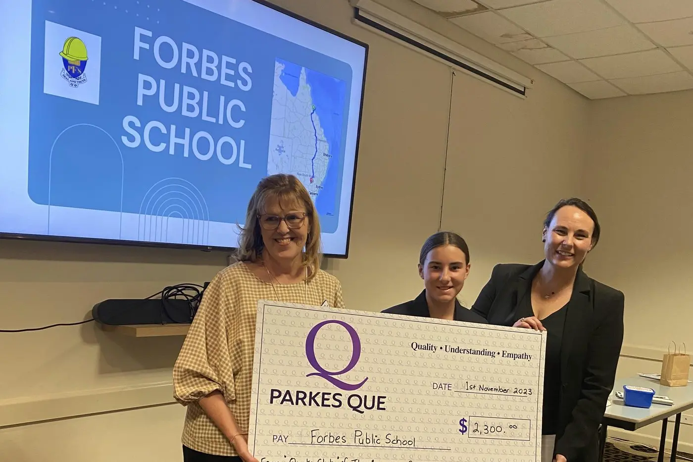 QUE president Kath Whitchurch presents Forbes Public School vice captain Milly Ridley and principal Meg Staples with the generous donation from Thuringowa Quota Club. Photo supplied