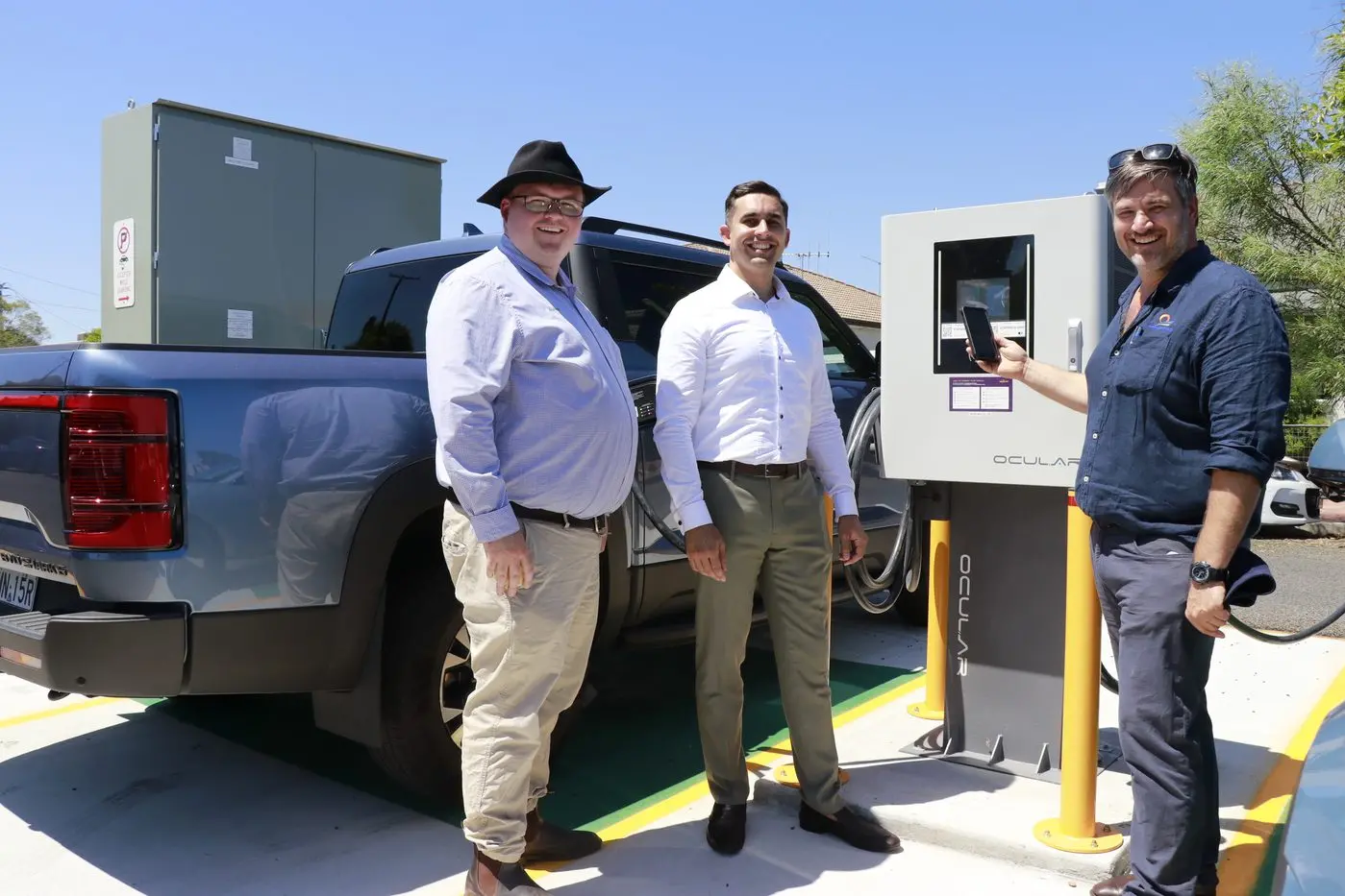 Cr Aidan Clark, EVSE Business Development Manager Krishna Thiers and Council\\'s manager waste and environment Paul Adams watch the vehicles charging. 