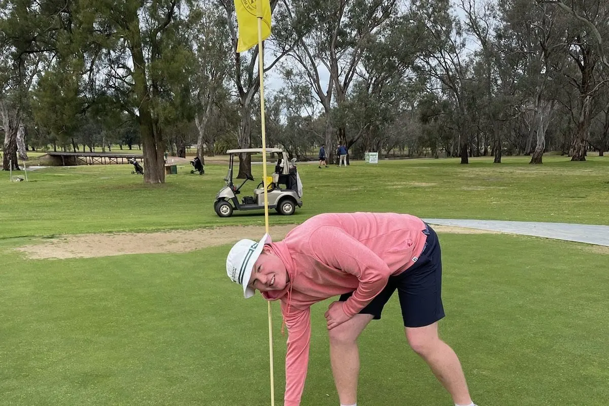 Reggie Murray retrieves his ball from the cup after his hole-in-one. Image supplied