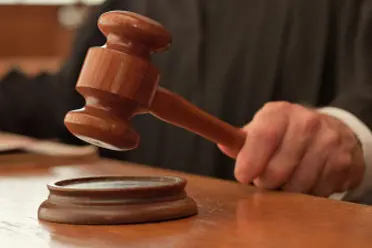 <p>Judge holding gavel in courtroom</p>\\n