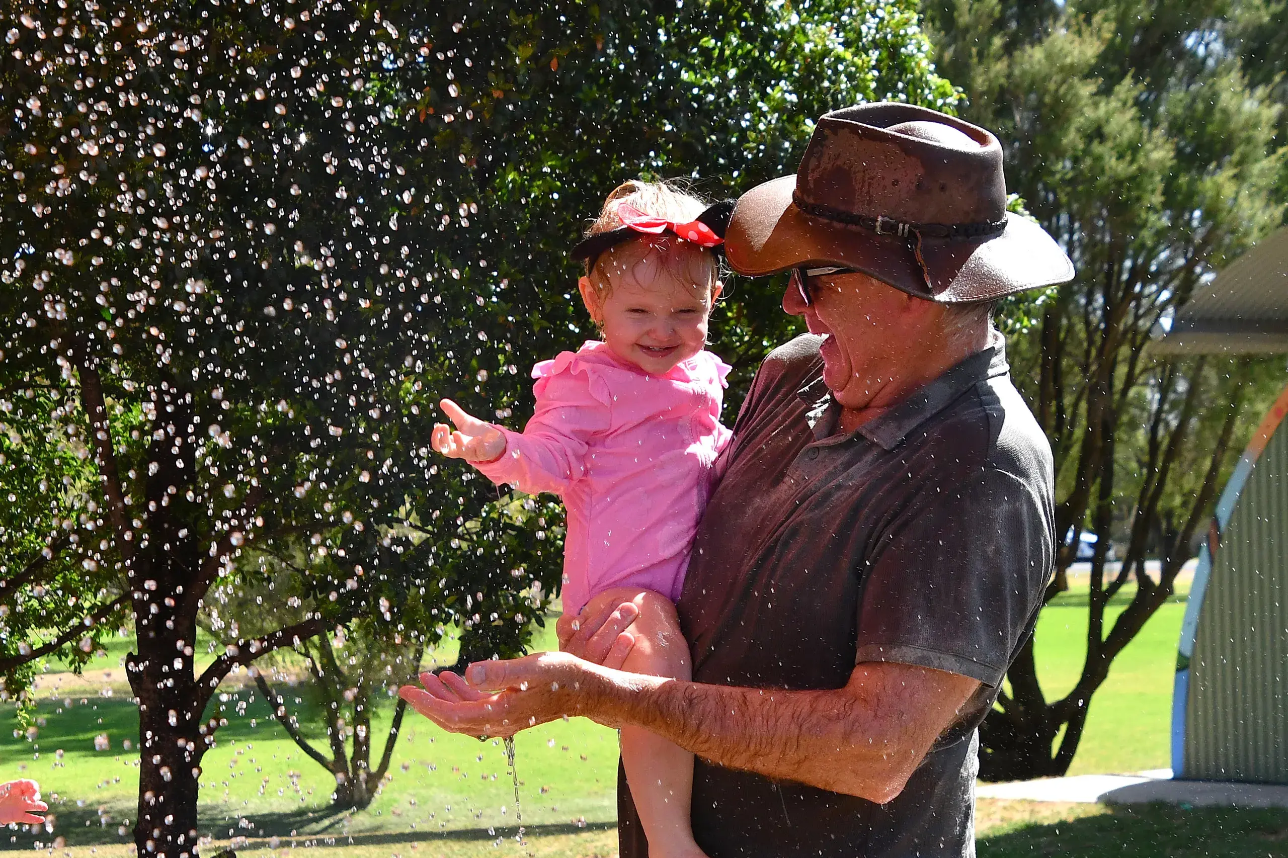 <p>Andie Dickerson-King with her great grandfather Mel Sinclair cooling off at the splash park by the lake on Saturday. PHOTO: Jenny Kingham</p>\\n