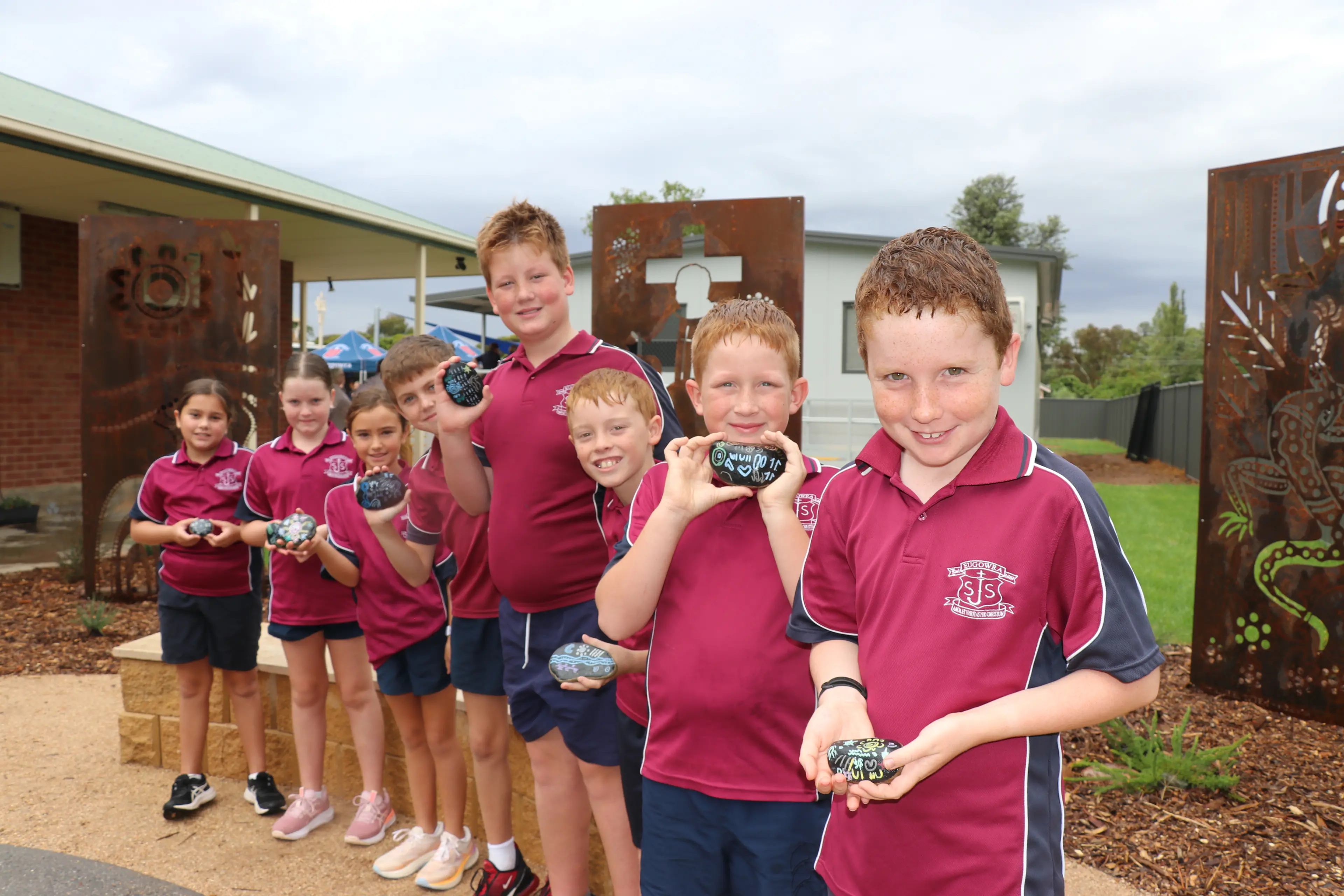 <p>Milah, Lexi, Indiana, Cruz, Teddy, William, Dusty and Joseph place their story stones in the new yarning circle at St Joseph\\u2019s Eugowra.</p>\\n