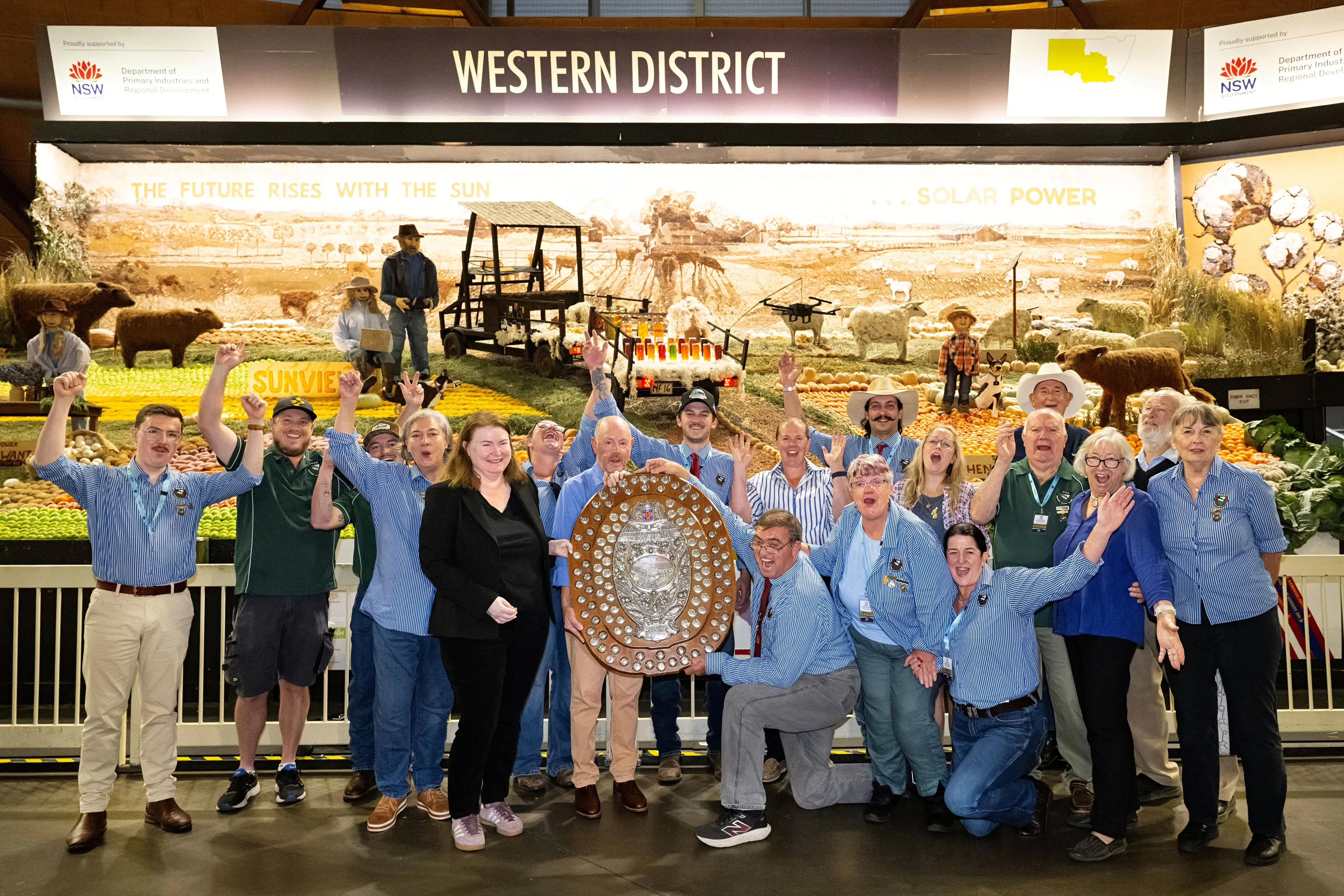 <p>Stuart Muller (kneeling, holding shield) and the Western District Exhibit team celebrate. PHOTO: RAS NSW</p>\\n