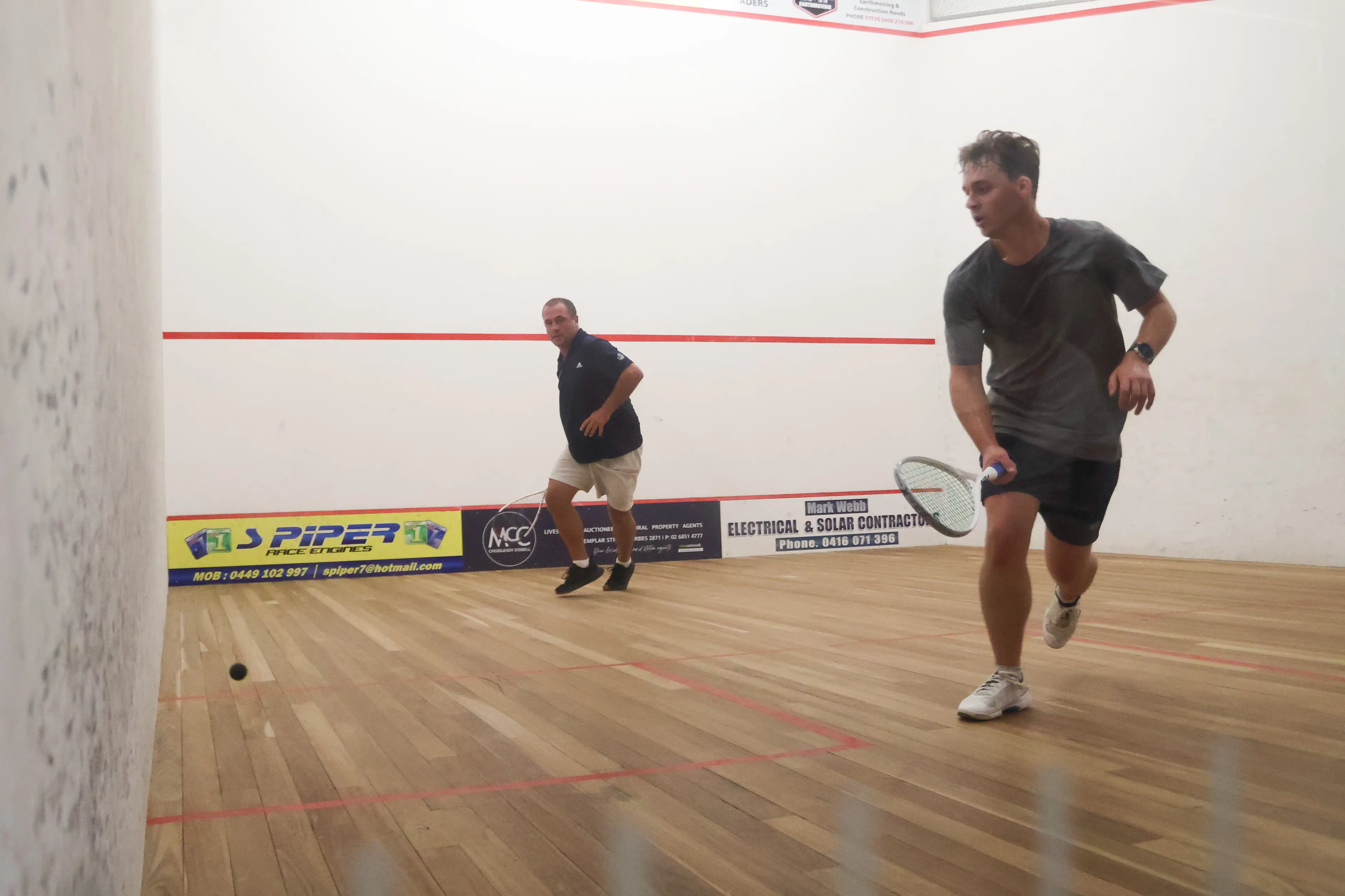 <p>Daniel Bayley and Riley Gould on court at the recent Forbes Squash Open. PHOTO: Adrian Simmons</p>\\n