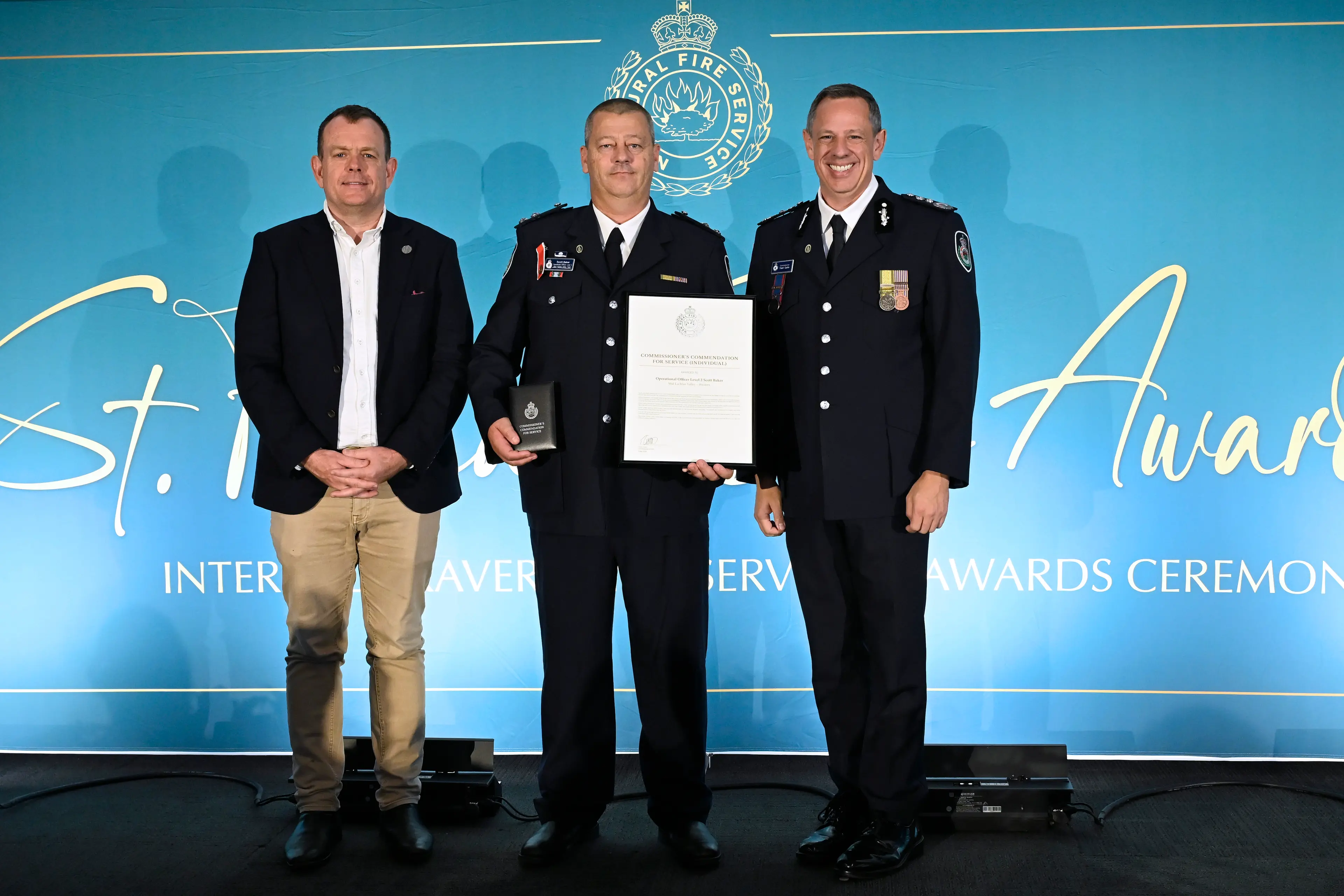 <p>MLC Stephen Lawrence and NSW RFS Commissioner Trent Curtin presented Scott Baker from Parkes a Commissioner\\'s Commendation for Service for his swift and life-saving actions when a man collapsed at the Parkes Hockey Fields last June. PHOTO: RFS NSW</p>\\n