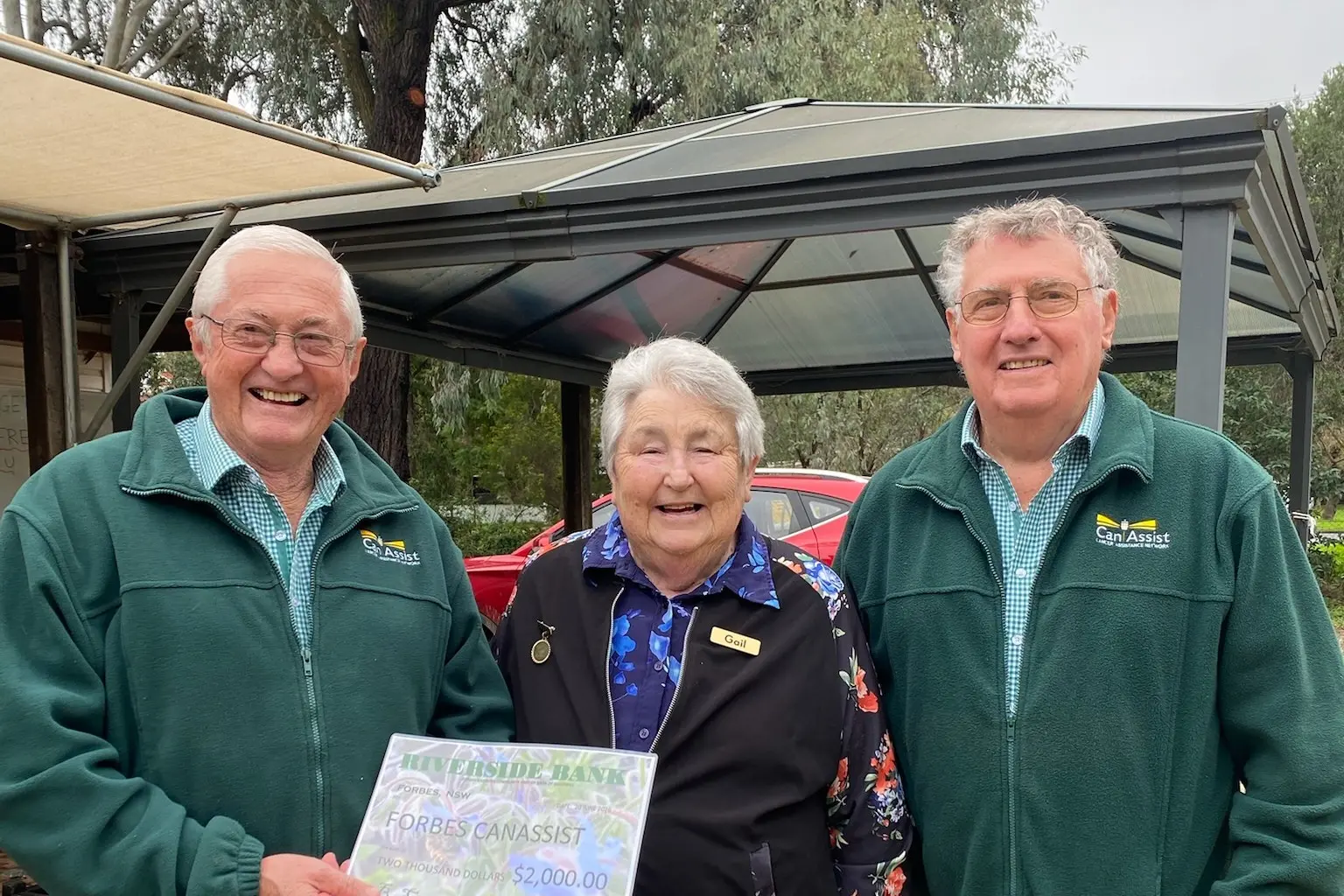 <p>Forbes Riverside Community Gardens president Gail Irvine presents CanAssist\\'s John Schrader and Rex Barton with the cheque from the Mother\\'s Day fundraiser. </p>\\n